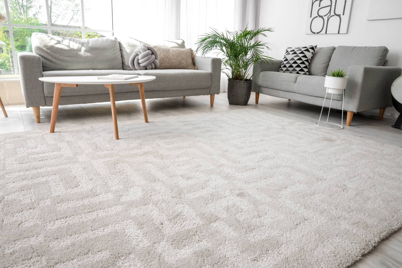 Gray modern carpeting in a contemporary living room with sofa and art at Home Carpet & Window Treatments near Los Angeles, California